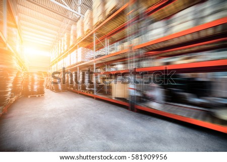 Warehouse industrial and logistics companies. The boxes on high shelves stocked. Motion blur effect. Bright sunlight. Royalty-Free Stock Photo #581909956
