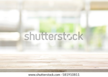 Wood table top on blur kitchen window background - can be used for display or montage your products (foods)