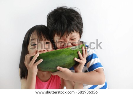 Cute little Asian boy and girl enjoying watermelon isolated on white background