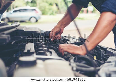 Man with checking car engine. Royalty-Free Stock Photo #581941585