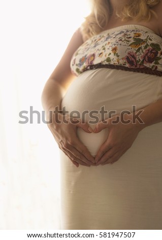 Pregnant woman making heart on her stomach