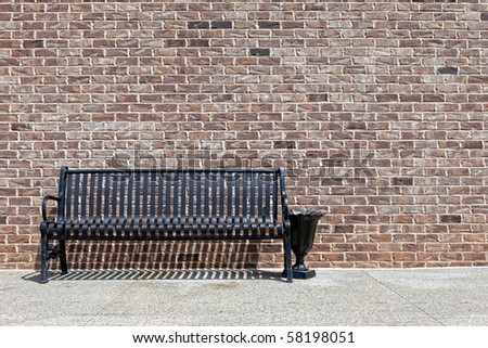 Park bench against a brick wall