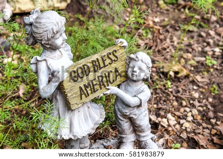 Religious figurine of kids holding a GOD bless America sign