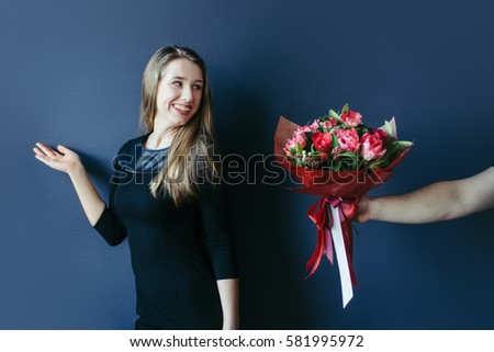Cute girl getting bouquet of red tulips. Boyfriend giving tulips.