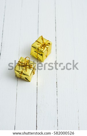 two golden gift boxes on white wooden table background