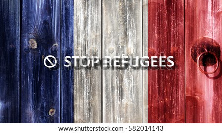 French flag painted on an old wooden door. Next to the door handle text Stop Refugees.