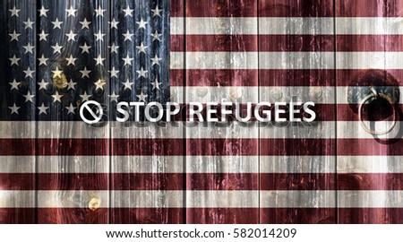 Flag of the United States painted on an old wooden door. Next to the door handle text Stop Refugees.