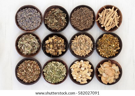 Herbs to help sleeping and anxiety disorders in wooden bowls on distressed white wood background. 