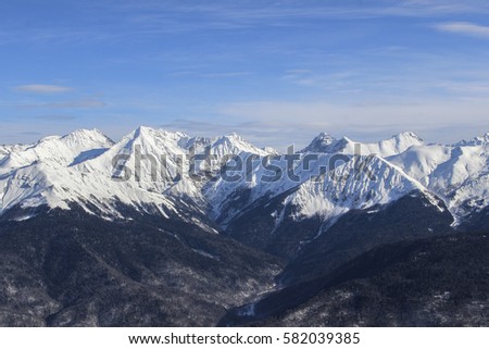 Picturesque, beautiful view to snow-capped peaks of the Caucasus mountains. The mountains in Krasnaya Polyana, Rosa Khutor Alpine Resort. Sochi is the capital of Winter Olympic Games 2014