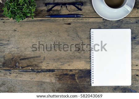Wood business office desk table with notebook, cup of coffee and supplies on top view business desk with copy space at text of picture. Creative table. Graphic design. Dark tone. Flat lay.