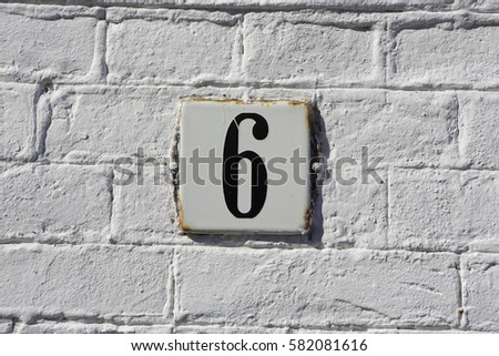 House number 6 slate sign on wall 