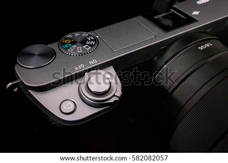 Shutter button on a DSLR camera, mirrorless, close up image isolated on black 