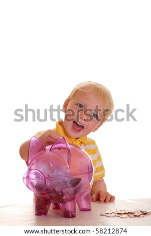 Happy kid fills his piggy bank with coins