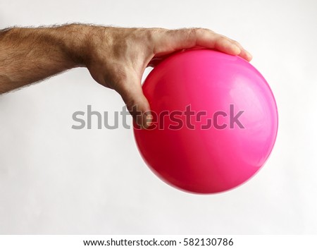 Man's hand holding a ball for gymnastics Royalty-Free Stock Photo #582130786