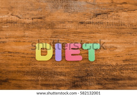 diet word made from colorful letters lie on wooden table background. healthy food sign, symbol, idea