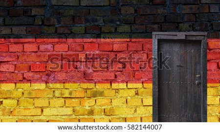 German flag painted on an old brick wall. Closed door in a wall