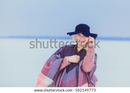Scenic picture of winter and joyful beautiful girl in warm clothes. Cold winter time.