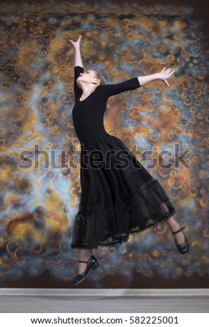 Black Swan. The young beautiful dancer in black dress dancing in the studio