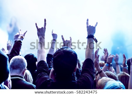cheering crowd at a rock concert Royalty-Free Stock Photo #582243475