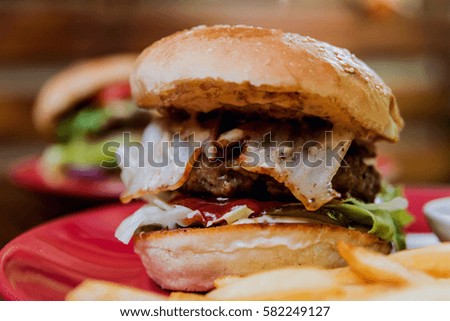 Big cheeseburger and chips on a plate. Restaurant