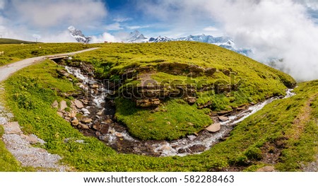 Great view of alpine misty hills and glacier stream. Picturesque and gorgeous scene. Location place Swiss alps, Grindelwald valley, Bernese Oberland, Europe. Discover the world of beauty.