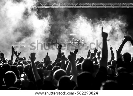 cheering crowd at a rock concert Royalty-Free Stock Photo #582293824