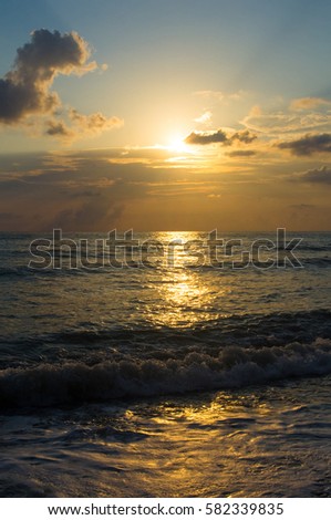 solar path on the sea on a Sunset and yellow sky with clouds