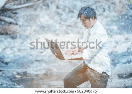 asian  business man using laptop work his job in relaxation area forest
