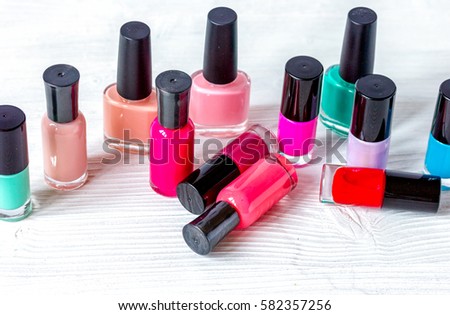 bottles of colored nail polish on wooden background