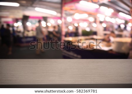 image of wooden table in front of abstract blurred background of market or shopping mall and people . can be used for display or montage your products.Mock up for display of product