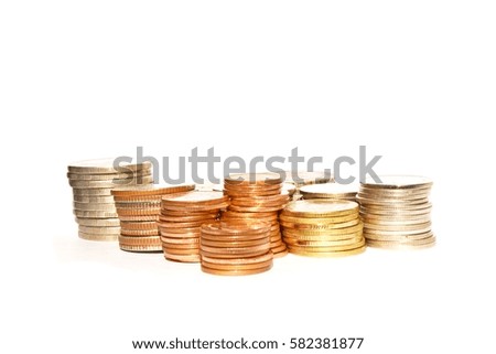 Many stacks of coins in various sizes and valued on white background