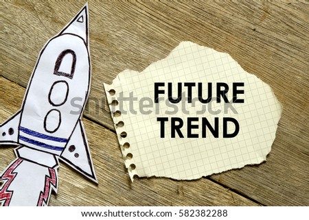 Paper rocket with paper written FUTURE TREND on wooden background. Business concept