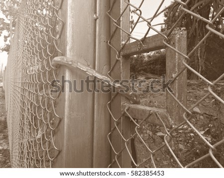 Lock the door of wire mesh fence with a chain.