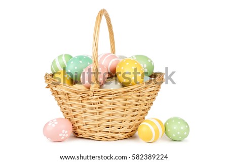 Easter basket filled with hand painted pastel Easter Eggs over a white background Royalty-Free Stock Photo #582389224