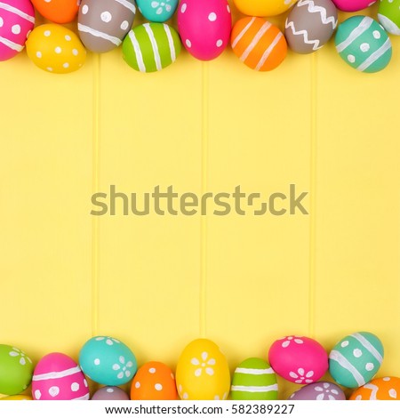 Colorful Easter egg double border against a yellow wood background Royalty-Free Stock Photo #582389227