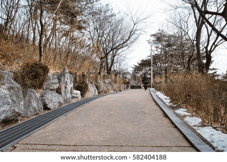 unidentified person walk surrounded by beautiful Korea nature at hill top during winter season