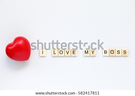 I LOVE MY BOSS text word made with wood blocks and Red Heart on table White.