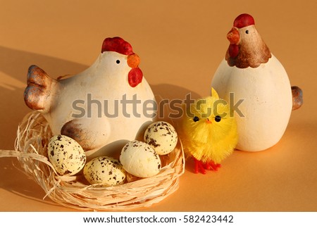 Easter concept. Ceramic figures of chicken in a nest with eggs,  cock and yellow chick