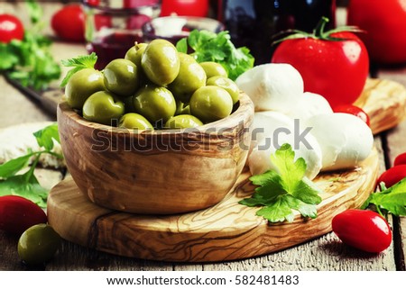 Green olives, cheese, tomatoes and wine, still life, selective focus
