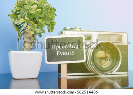 UPCOMING PLAN word, wooden signage, vintage camera and artificial plant on wooden desk with reflection.