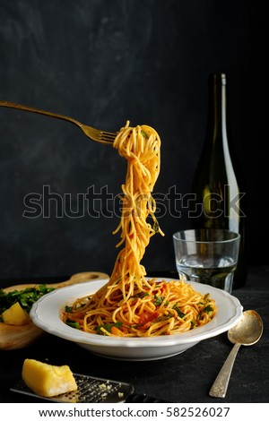 Spaghetti on a fork. Pasta with fresh tomatoes and herbs Royalty-Free Stock Photo #582526027
