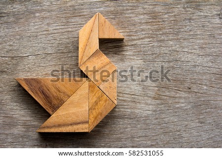 Wooden tangram puzzle in swan shape background
