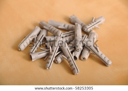 pile of plastic straddling dowels on a brown wooden background