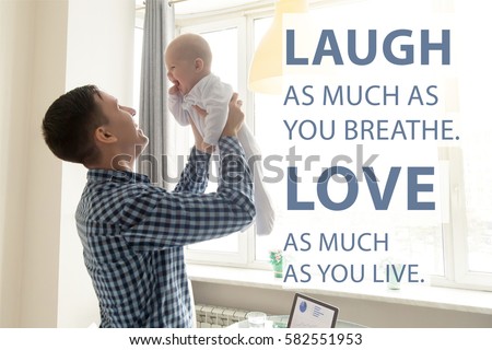 Happy young father lifting cute baby up high in the air near the working place with laptop. Photo with motivational text "Laugh as much as you breathe. Love as much as you live". Square image 