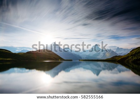 High mountain peaks glowing in the moonlight. Dramatic scene. Location place Bachalpsee in Swiss alps, Grindelwald valley, Bernese Oberland, Europe. Artistic picture. Discover the world of beauty.
