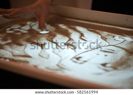 Sand animation. Hands girls draw sand
