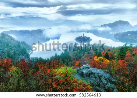 Fantastic view of misty autumn scenery at Bled lake with church on island . Dramatic , picturesque fall scene. Popular tourist attraction. Bled town, Slovenia, Europe. Artistic picture. Beauty world.