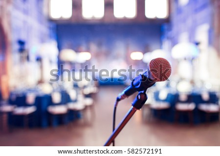Microphone over the Abstract blurred photo of conference hall or wedding banquet background