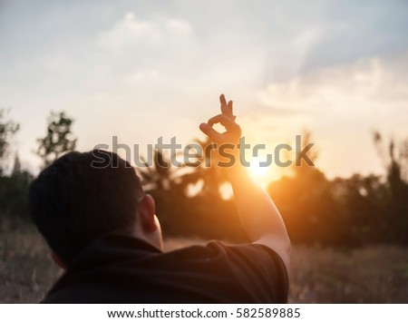 Man show hands silhouette sunset background