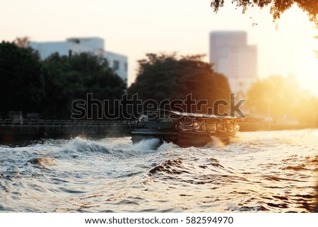 A traditional boat in the river city on sunset background, dramatic color tone